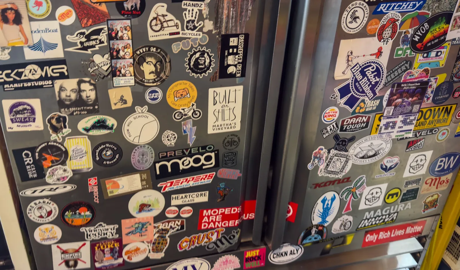 Sticker-covered fridge inside the PA Club, where Mo's Lunch serves