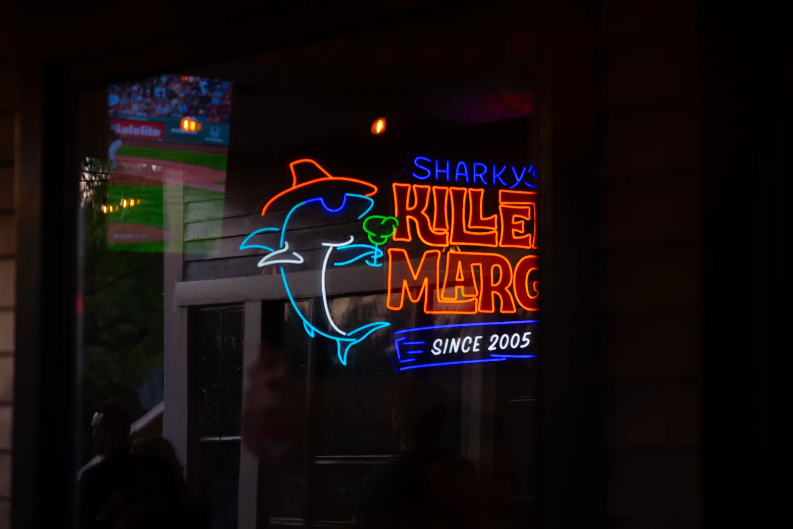 Sharky's Killer Margaritas neon in the window, a ballgame reflected in the glass, Oak Bluffs