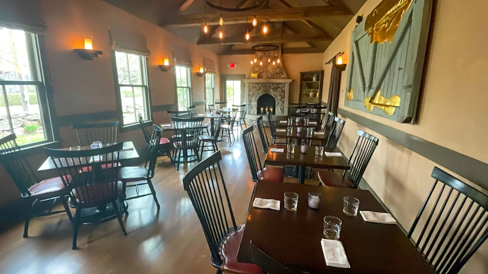 The dining room at State Road Restaurant, laid tables and the fireplace at the far end