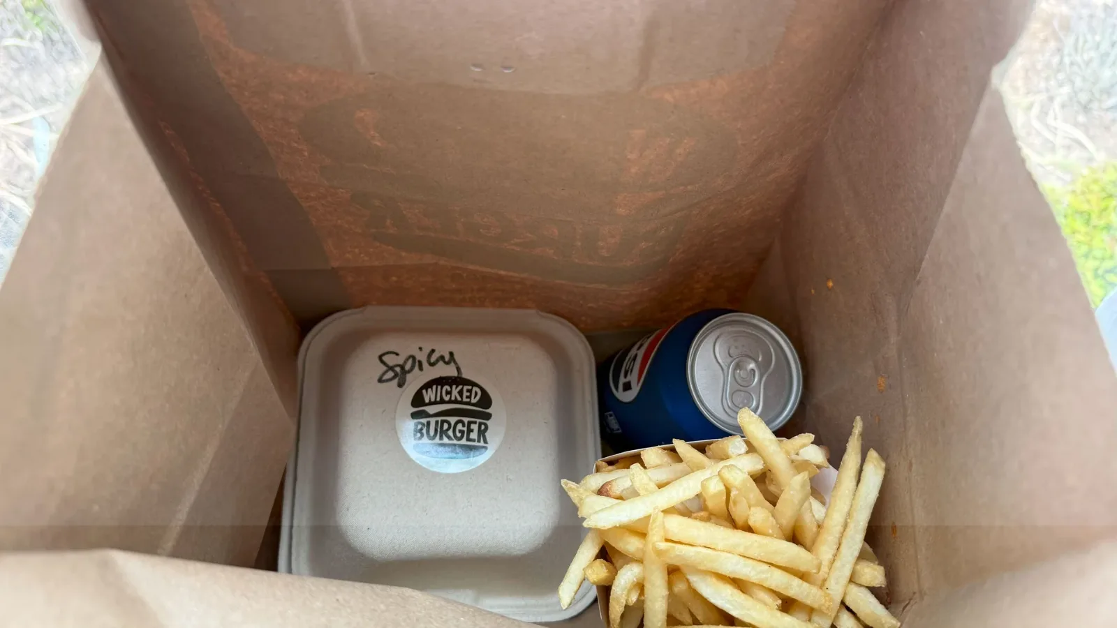 A spicy Wicked Burger, fries and a soda packed in a takeout bag, Edgartown